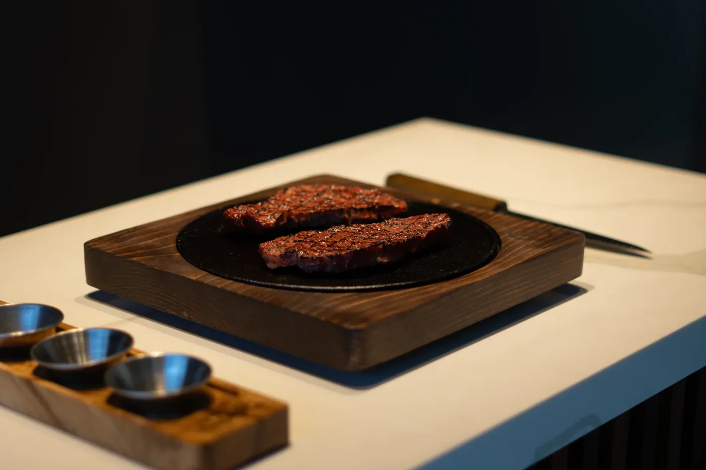 Corte de carne servido sobre plancha caliente montada en base de madera
